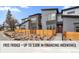 Modern two-story townhome with gray siding, wood fence, and landscaped walkway at 9445 W 58Th Cir # C, Arvada, CO 80002