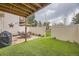 Fenced backyard with grass, patio area, table, chairs, umbrella, and barbecue at 9689 W Chatfield Ave # H, Littleton, CO 80128