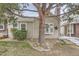 Charming home exterior featuring a large tree, bay window, and a lovely front yard at 9689 W Chatfield Ave # H, Littleton, CO 80128