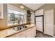 Cozy kitchen with bright white cabinetry, stainless sink, and bright window looking out to mature landscape at 9689 W Chatfield Ave # H, Littleton, CO 80128
