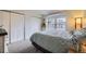 Inviting main bedroom with plush carpet, large closets, and bright, sunlit window at 9689 W Chatfield Ave # H, Littleton, CO 80128