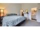 Comfortable bedroom featuring a bed with patterned comforter and ensuite bath at 9689 W Chatfield Ave # H, Littleton, CO 80128