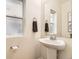 Well-lit bathroom with a pedestal sink, decorative mirror, and a window at 1998 Coach House Loop, Castle Rock, CO 80109