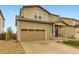 Two-story home featuring a two-car garage, blue door, and well-maintained front yard with rock landscaping at 1998 Coach House Loop, Castle Rock, CO 80109