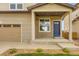 Home exterior showcasing a two-car garage and a welcoming blue front door with a covered porch at 1998 Coach House Loop, Castle Rock, CO 80109