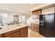 Bright kitchen with granite countertops, island, black fridge, and stylish cabinets at 1998 Coach House Loop, Castle Rock, CO 80109
