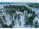 Aerial view of a house on a snowy lot with a detached garage at 757 N Bluff Dr, Franktown, CO 80116