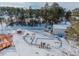 Aerial view of a home with a pool and detached garage in the snow at 757 N Bluff Dr, Franktown, CO 80116