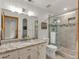 Modern bathroom featuring a vanity with granite countertop, a large mirror, and a glass-enclosed shower at 757 N Bluff Dr, Franktown, CO 80116