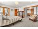 Bedroom with striped bedding, sitting area, and private balcony access at 757 N Bluff Dr, Franktown, CO 80116