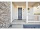 Gray front door with a white porch and stone accents at 13432 E 110Th Way, Commerce City, CO 80022