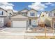 Two-story house with stone and beige siding, two-car garage, and front porch at 13432 E 110Th Way, Commerce City, CO 80022