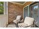 Private covered balcony with stone accents, comfortable seating, and a view of the neighborhood at 4385 S Balsam St # 10-103, Littleton, CO 80123