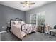 Comfortable bedroom features a wrought iron bed frame, ceiling fan, and a window to let in natural light at 4385 S Balsam St # 10-103, Littleton, CO 80123