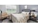 Cozy bedroom with a decorative chair, black metal bed frame, and neutral decor at 4385 S Balsam St # 10-103, Littleton, CO 80123