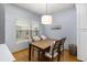 Cozy dining room features a wooden table, padded chairs, and natural light from the window with blinds at 4385 S Balsam St # 10-103, Littleton, CO 80123