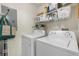 Bright laundry room with a front loading washer and dryer, plus wire shelving for storage at 4385 S Balsam St # 10-103, Littleton, CO 80123