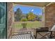 View from covered patio showcasing lush green grass, mature trees, and other townhome buildings at 4385 S Balsam St # 10-103, Littleton, CO 80123