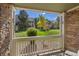 View from the balcony showcasing lush green grass, mature trees, and other townhome buildings at 4385 S Balsam St # 10-103, Littleton, CO 80123