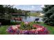 Scenic view of a tranquil pond with flower beds and benches on a clear day at 4385 S Balsam St # 10-103, Littleton, CO 80123