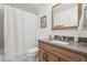 Bright bathroom featuring a granite countertop vanity and shower with white curtain at 12455 W Alameda Dr, Lakewood, CO 80228