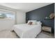 Cozy bedroom with a dark accent wall, soft textures, and natural light from a window at 12455 W Alameda Dr, Lakewood, CO 80228