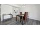 Modern dining area with sleek table, four chairs, built-in shelving, and ample lighting at 12455 W Alameda Dr, Lakewood, CO 80228
