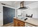 Open kitchen with island cooktop and stainless hood, adjacent to dining area at 12455 W Alameda Dr, Lakewood, CO 80228