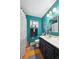 Stylish bathroom with teal walls, a modern vanity, and a decorative shower curtain, blending aesthetics and functionality at 6267 Fenton St, Arvada, CO 80003