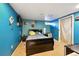 This vibrant bedroom features sleek, dark furniture and bright blue walls at 6267 Fenton St, Arvada, CO 80003