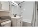 Clean bathroom with white subway tile in shower, black hardware, and a matching black wire storage basket at 1201 Moline St, Aurora, CO 80010