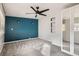 Bedroom with blue accent wall, ceiling fan, carpet, and mirror door closet at 1201 Moline St, Aurora, CO 80010