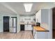 Updated kitchen featuring stainless steel refrigerator, butcher block counters, white cabinetry, and black hardware at 1201 Moline St, Aurora, CO 80010