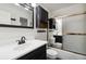 Traditional bathroom features a tub, shower, single sink, and vanity with dark finishes at 8737 Santa Fe Dr, Thornton, CO 80260