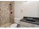 Well-lit bathroom featuring a tiled shower and a modern vanity sink at 8737 Santa Fe Dr, Thornton, CO 80260