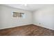 A bright, empty bedroom with a window and wood floors at 8737 Santa Fe Dr, Thornton, CO 80260