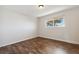 A bright, empty bedroom with a window and wood floors at 8737 Santa Fe Dr, Thornton, CO 80260