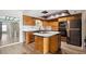 Cozy kitchen features wood cabinets, a central island cooktop, and modern appliances at 8737 Santa Fe Dr, Thornton, CO 80260
