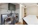 Updated laundry room features modern appliances, cabinets, and ample counter space at 8737 Santa Fe Dr, Thornton, CO 80260