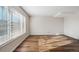 Spacious living room offers a large window, wood-look floors, and neutral colors at 8737 Santa Fe Dr, Thornton, CO 80260