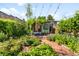 Charming backyard oasis with lush greenery, brick patio, and cozy outdoor seating area at 178 W Cedar Ave, Denver, CO 80223