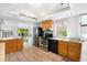Functional kitchen with stainless steel appliances, warm wood cabinets, and tile flooring at 178 W Cedar Ave, Denver, CO 80223