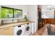 View of the laundry room with washer, dryer, window and access to the kitchen at 178 W Cedar Ave, Denver, CO 80223