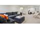 Finished basement with sectional sofa, two accent chairs, and a large TV at 3069 S Detroit Way, Denver, CO 80210