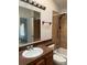 Full bathroom with a tiled shower, dark wood vanity, and a white sink and toilet at 4296 S Halifax Way, Aurora, CO 80013