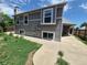 Exterior view of the home showing the side facade, a paved walkway, and some greenery at 4296 S Halifax Way, Aurora, CO 80013
