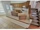 Traditional kitchen features oak cabinets, white appliances, and tiled countertops, adjacent to stairs at 4296 S Halifax Way, Aurora, CO 80013