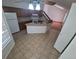 Open-concept kitchen features wood cabinets, tile counters, island with sink, and tiled flooring at 4296 S Halifax Way, Aurora, CO 80013