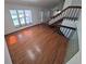 Bright living room showcasing hardwood floors, staircase, and large windows with natural light at 4296 S Halifax Way, Aurora, CO 80013