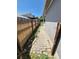 Narrow side yard with a brick path and a wooden fence, offering potential for landscaping at 4296 S Halifax Way, Aurora, CO 80013